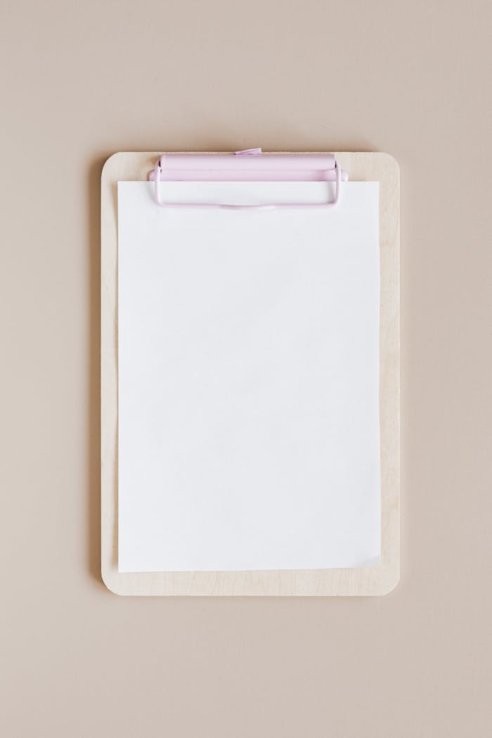 our-story Top view of a minimalist wooden clipboard with blank paper against a neutral background.
