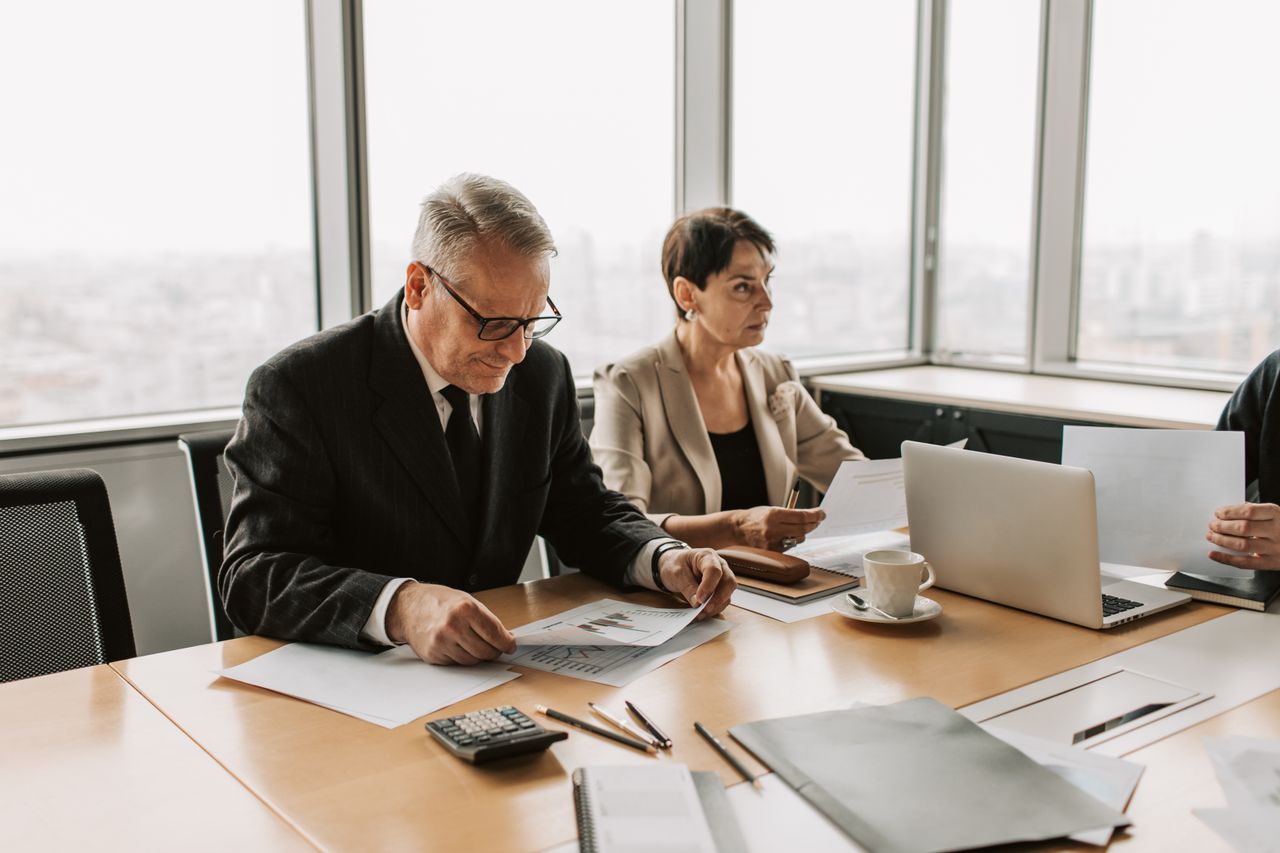 Corporate meeting with professionals discussing documents in a modern office.